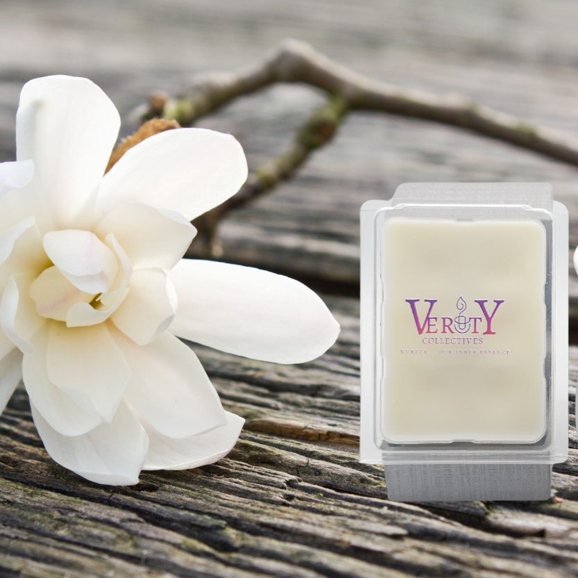 Verity Collectives wax melt with a magnolia flower in background on top of wood table