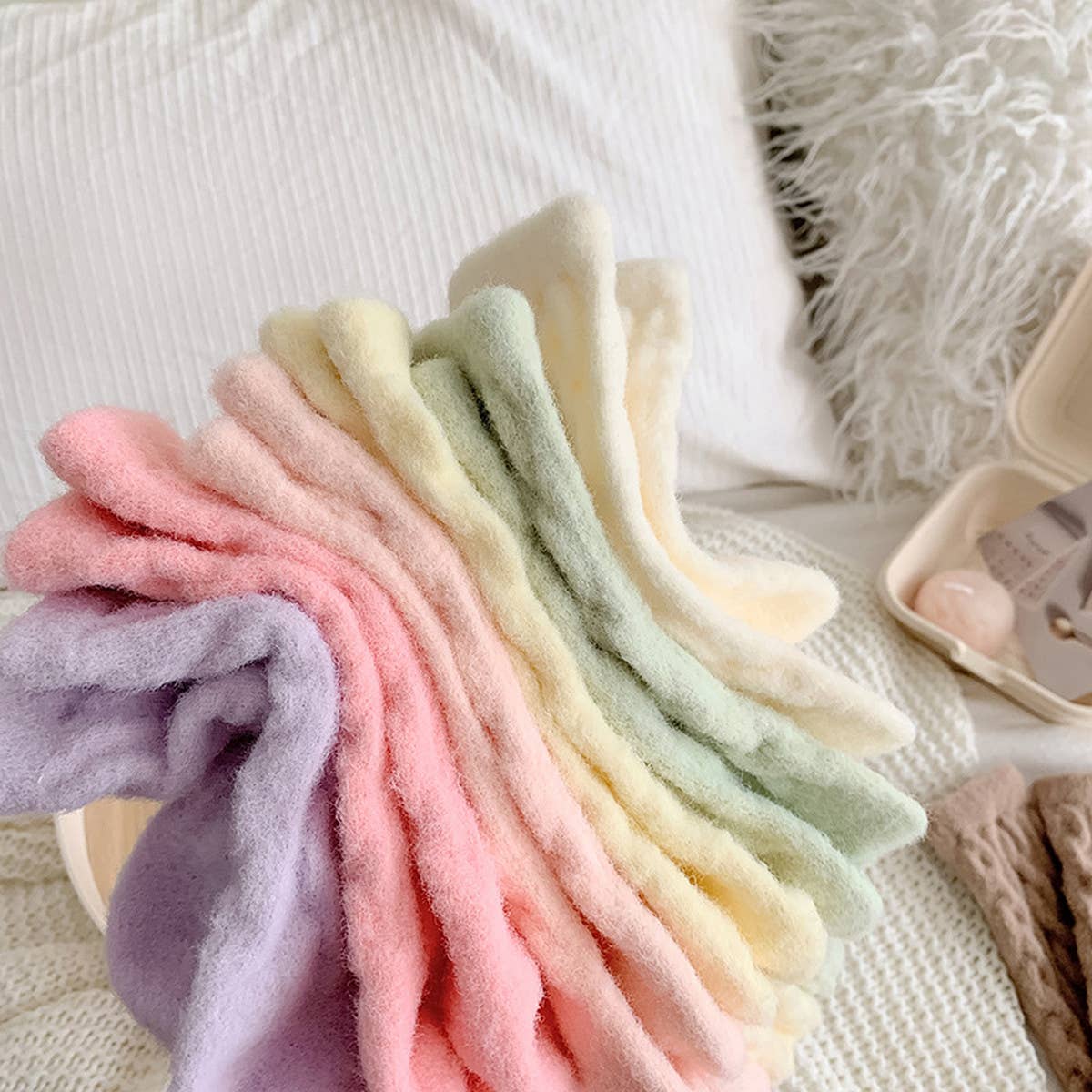 Stack of pastel-colored baby blankets on a textured surface
