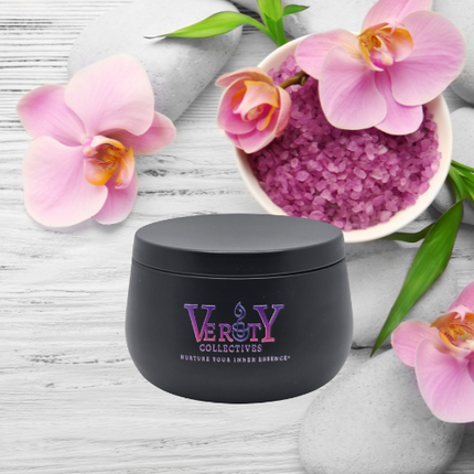 Verity Collectives black luxury candle with white and gray countertop, pink orchids, and pink sea salt in the background