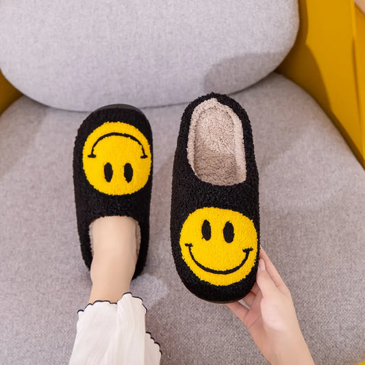 Black furry slippers with yellow smiley face on them