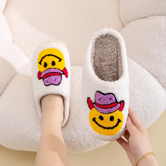 White furry slippers with a yellow smiley face wearing a pink cowboy hat