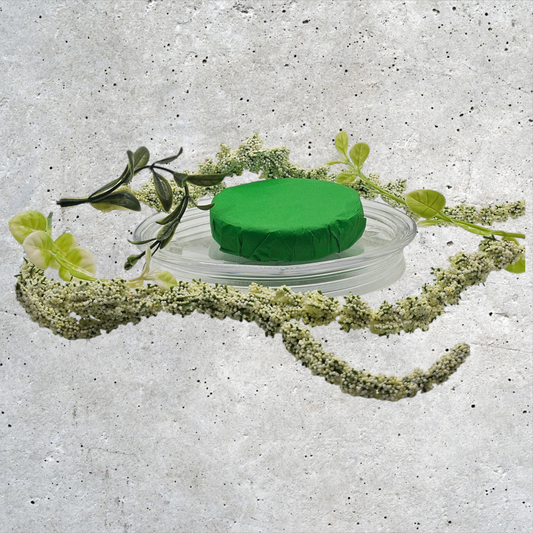 Verity Collectives Eucalyptus Shower Steamer  wrapped in green tissue paper with a green flower and speckled white background