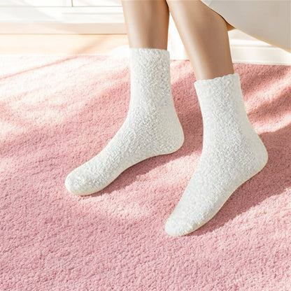 White fuzzy socks on woman with bathrobe on and pink carpet