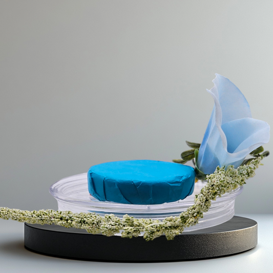 Verity Collectives Lucid Dreaming Shower Steamer wrapped in blue tissue paper with a blue flower and light bluish grey background