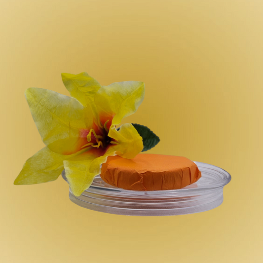 Verity Collectives Orange Shower Steamer wrapped in orange tissue apper with a yellow flower and orange yellow background