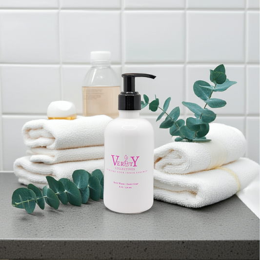Bottle of 'Very' hand cream on a bathroom counter with towels and eucalyptus leaves.