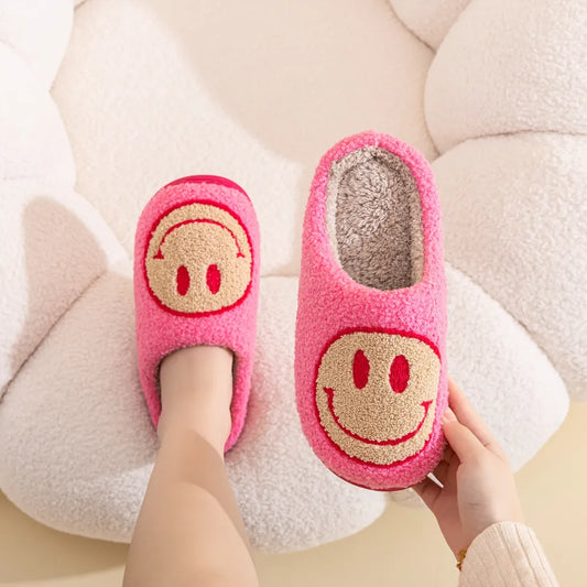 Pink furry slippers with tan colored smiley face