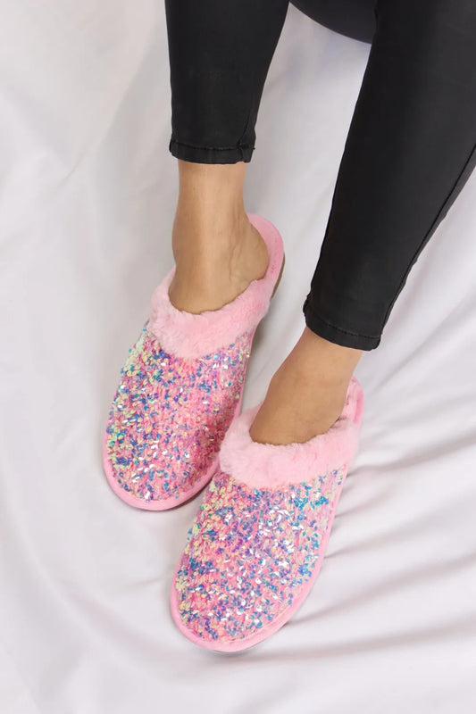 Pink slippers with fur around foot entry and blue, pink, and silver glitter all over slipper