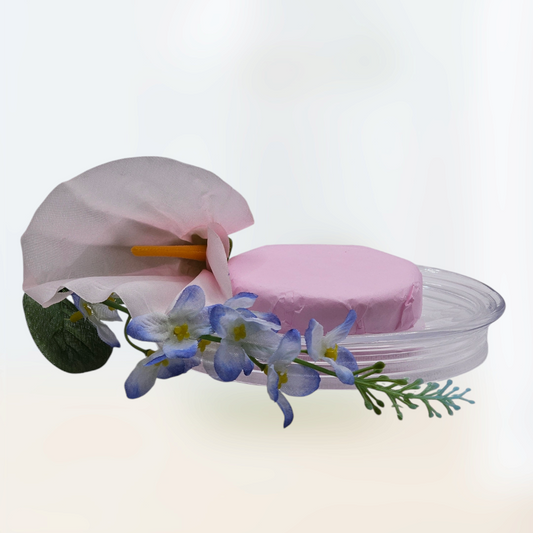 Verity Collectives Rose Shower Steamer wrapped in pink tissue paper with a lavender and white flower and a white background
