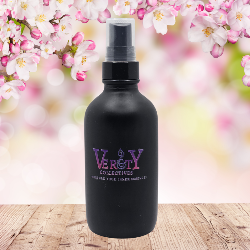 Verity Collectives Smell of Spring room spray sitting on a wood table with pink spring flowers in the background 