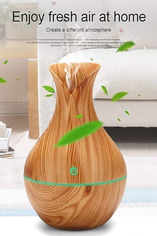 pear shape humidifier with air coming out top of it and white couch  and white carpet in background
