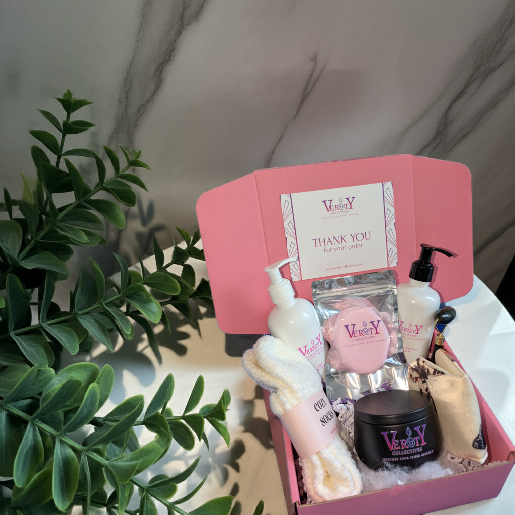 Pink gift box with beauty products on a marble surface with a plant in the foreground