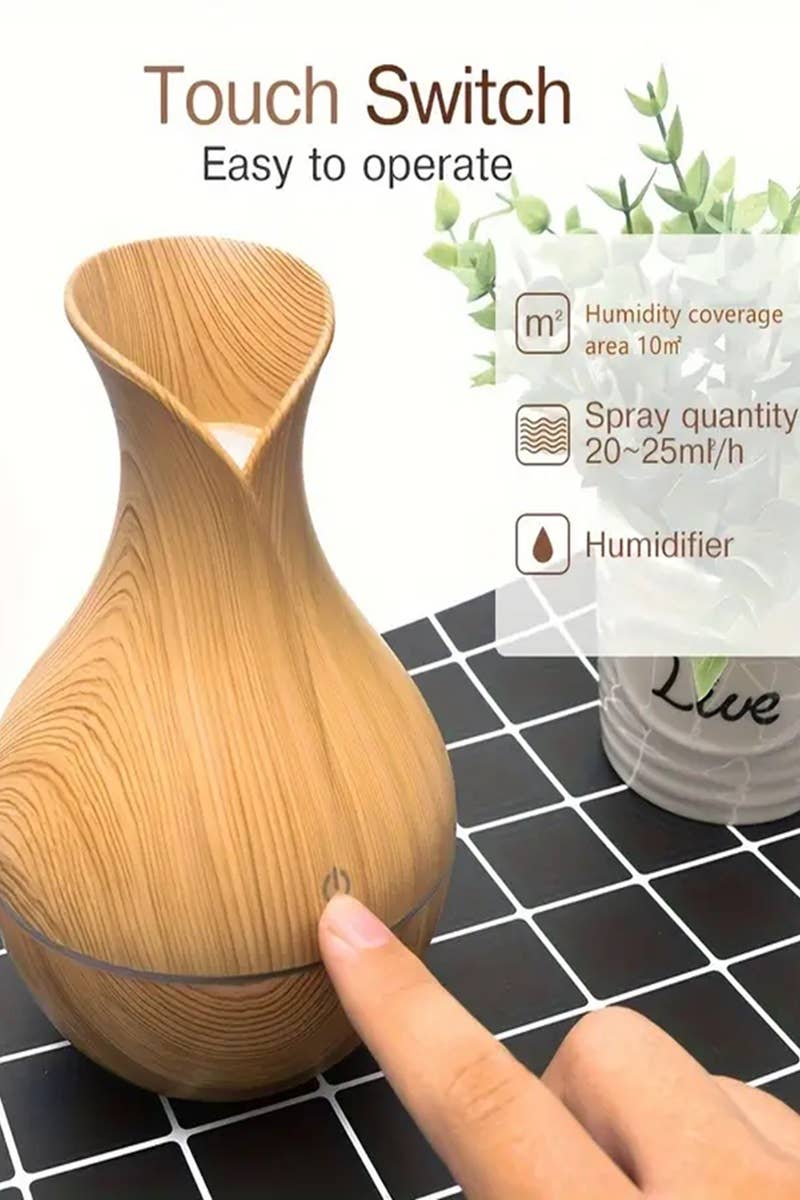 finger touching switch on light brown aromatherapy humidifier